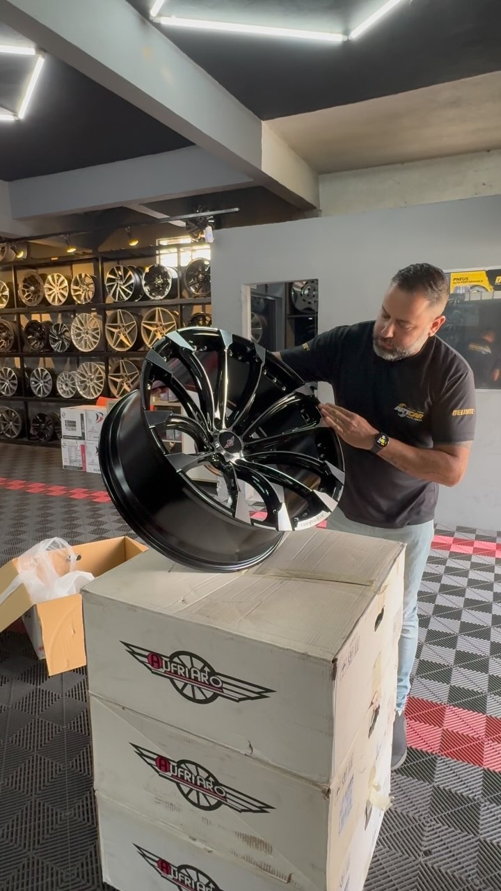 Profissional da ARTCAR Auto Center apresentando roda esportiva na loja